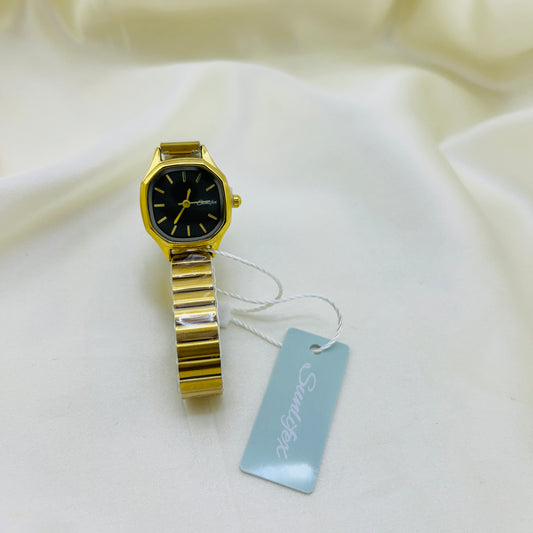 Gold watch with a tag on a white fabric background