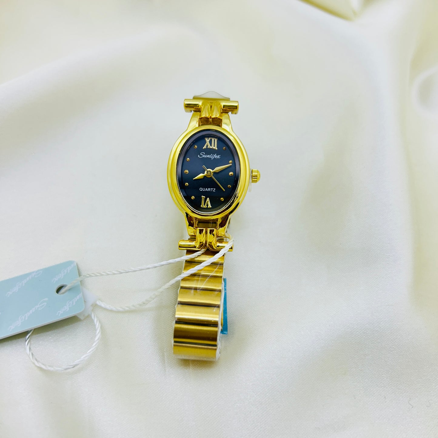 Gold wristwatch with a black face on a white background