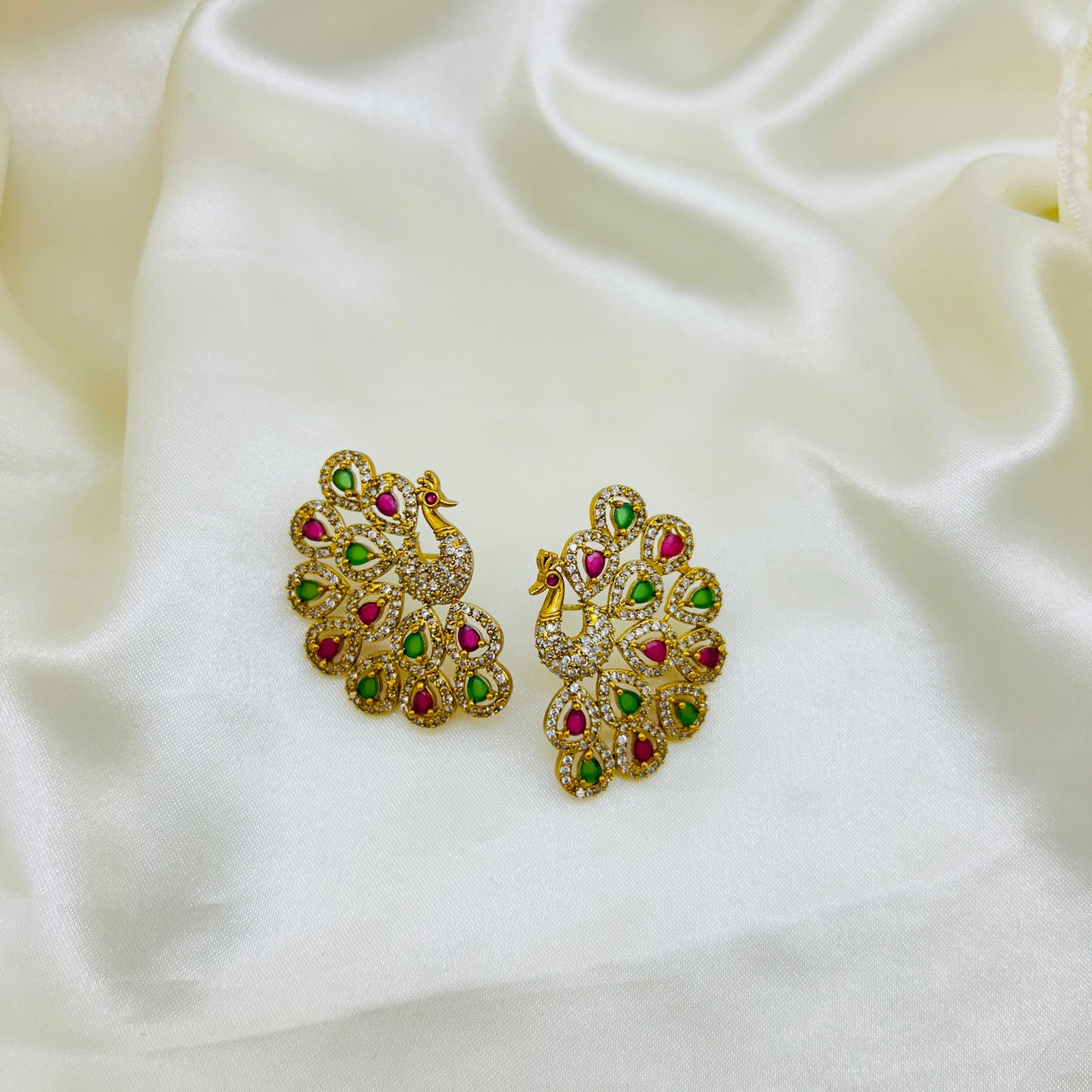 Gold peacock-shaped earrings with gemstones