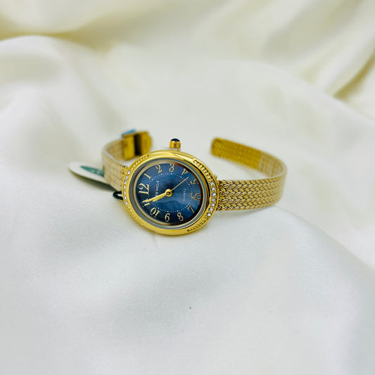 Gold watch with a blue face on a white fabric background