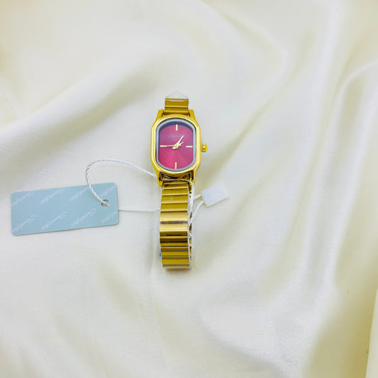 Gold watch with a pink face on a white fabric background