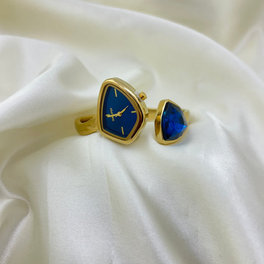 Gold cufflinks with blue stone on a white fabric background
