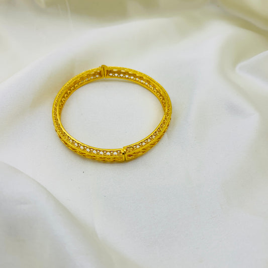 Gold bracelet on a white fabric background