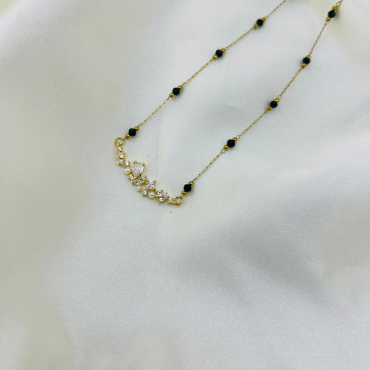 mangalsutra with black beads on a white background