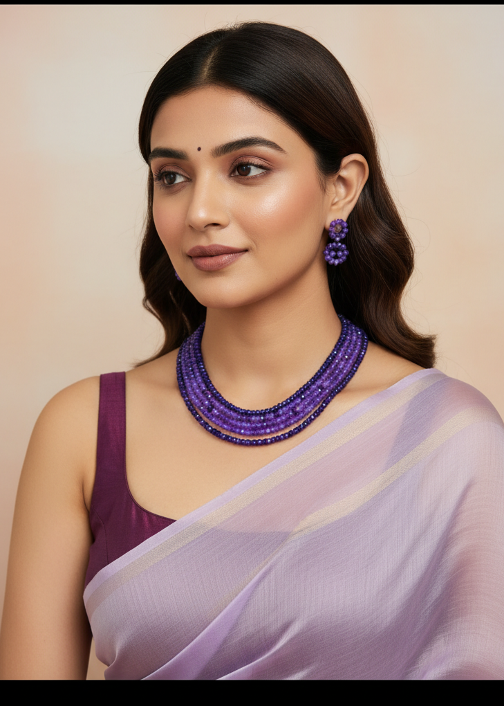 Woman wearing a purple saree with DEEVYATHA  jewelry on a beige background