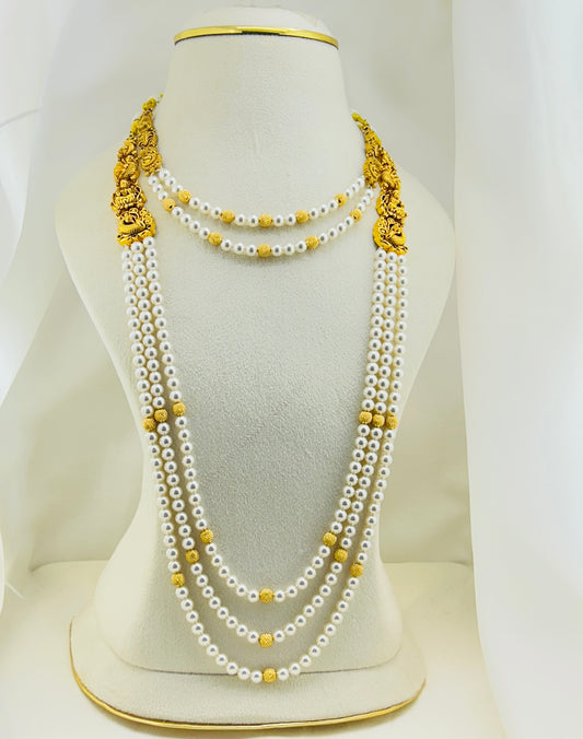 Gold and pearl necklace on a mannequin bust